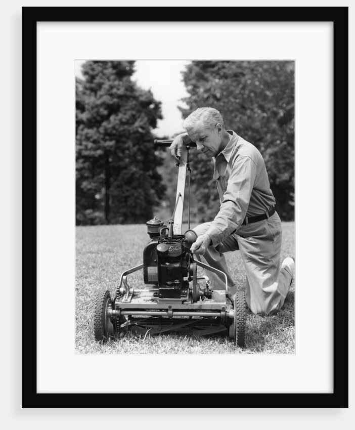 Elderly man in yard kneeling down to fix lawnmower by Anonymous
