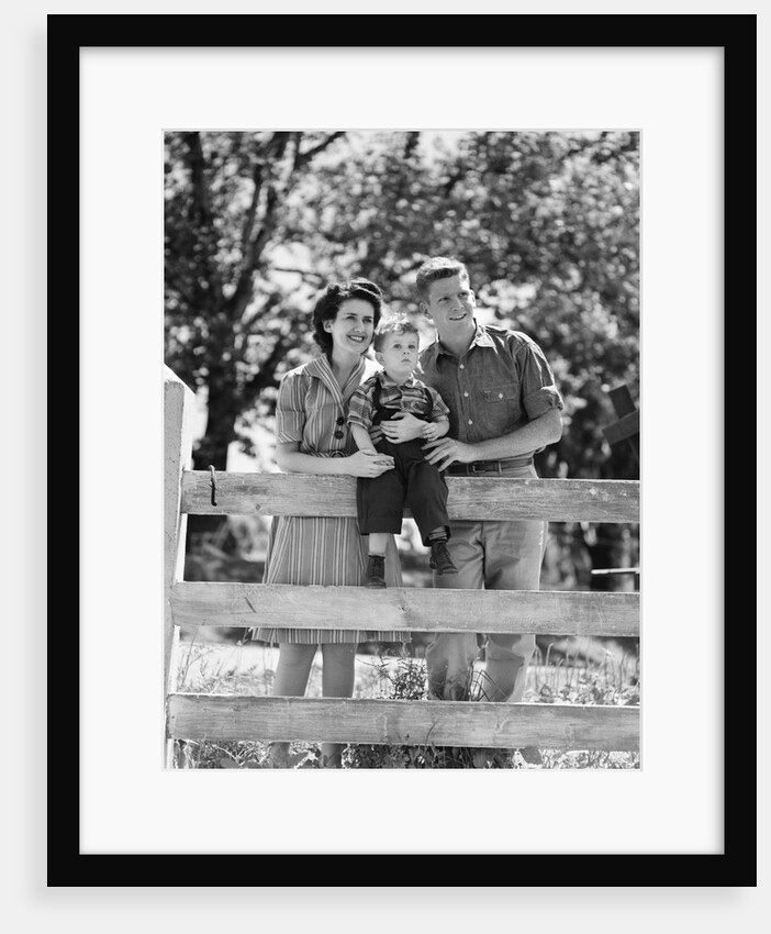 Smiling happy family mother father toddler boy portrait by farm fence by Anonymous