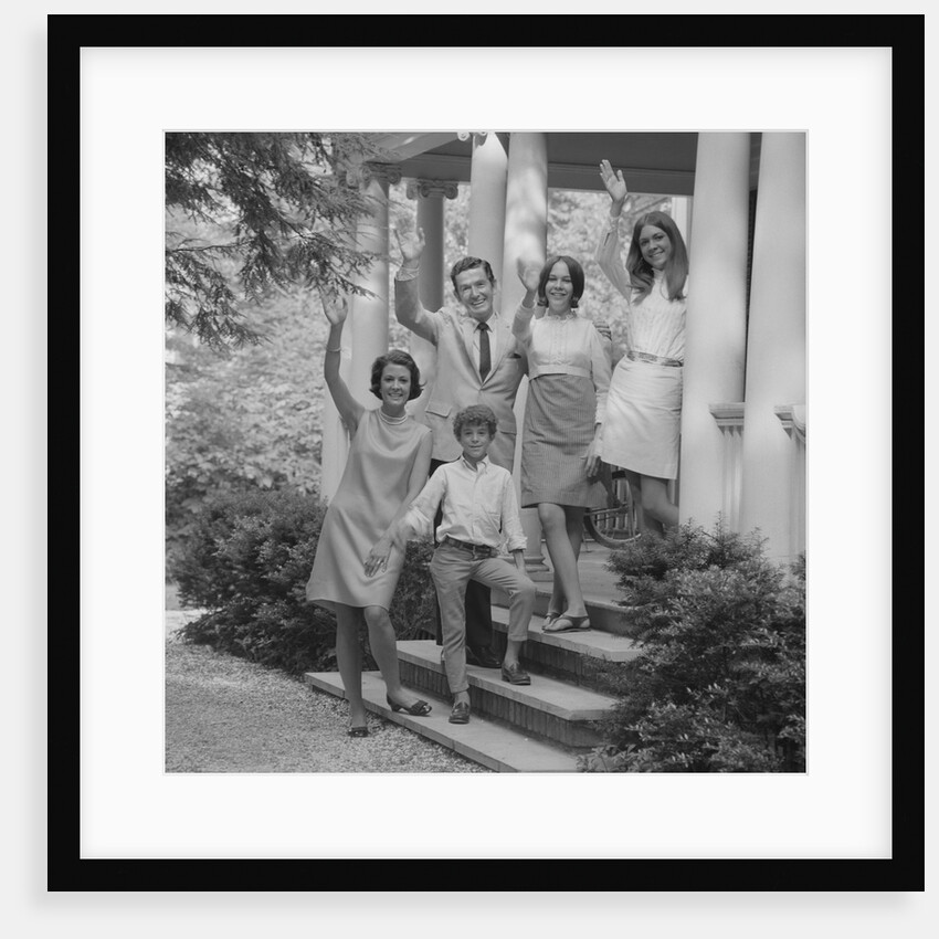 Family group of people standing on steps of house waving by Anonymous