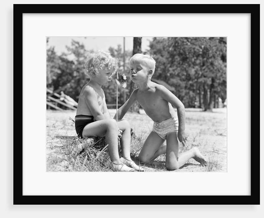 Blonde boy girl wearing bathing suits blowing on a pinwheel toy summer by Anonymous