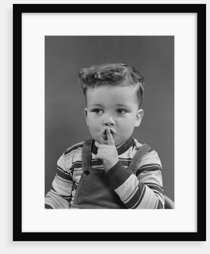 Little boy making shush shushing quiet silence sign with finger to mouth lips by Anonymous