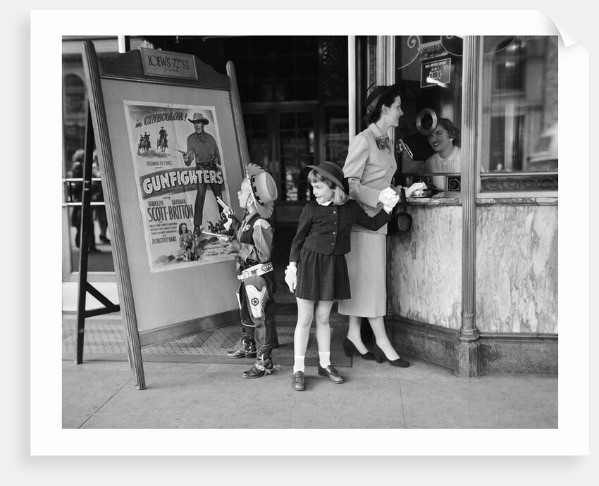 Mother and 2 children buying tickets to movie matinee boy wearing cowboy costume by Anonymous