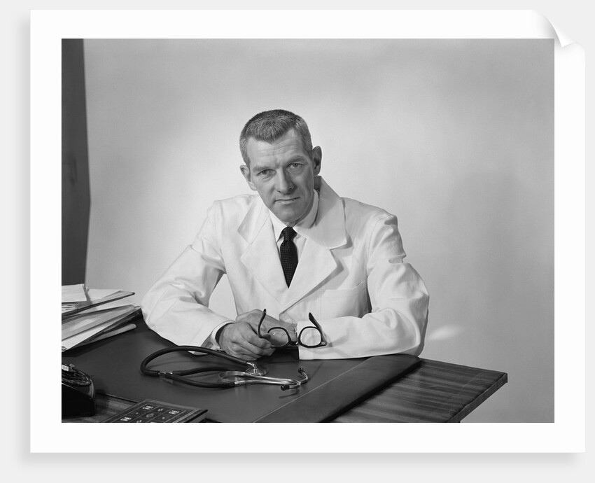 Portrait male doctor sitting at desk serious expression by Anonymous