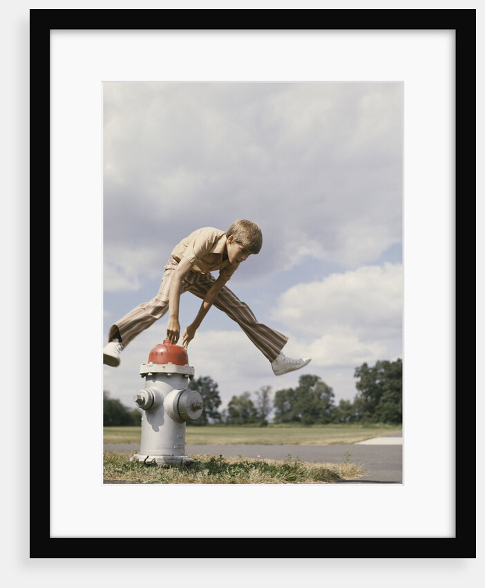 Boy jumping over fire hydrant by Anonymous