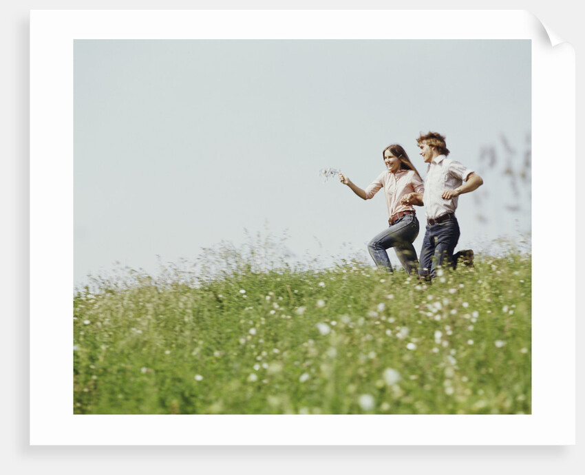 Young teen couple boy girl running field wildflowers by Anonymous