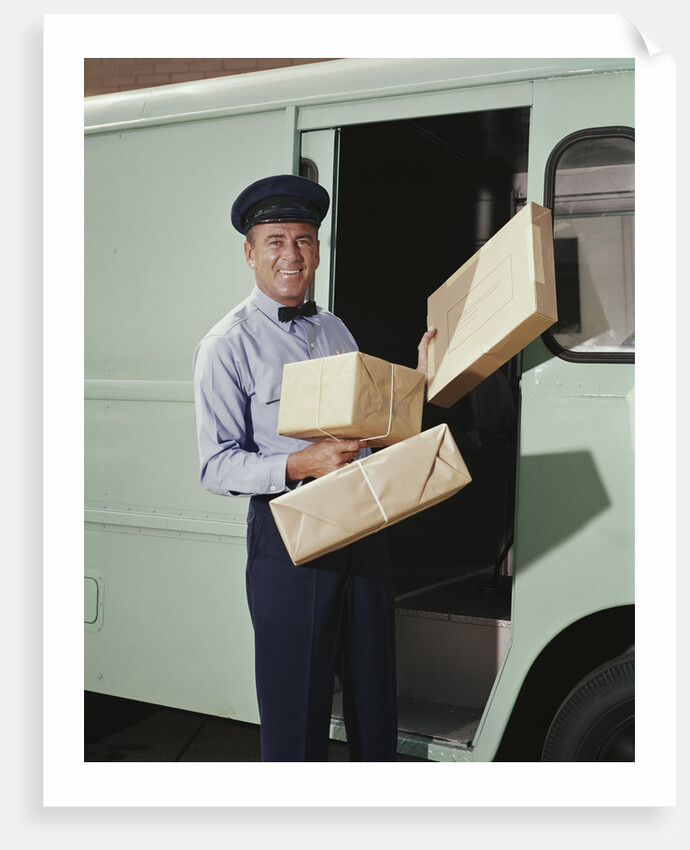 Delivery truck driver holding packages by Anonymous