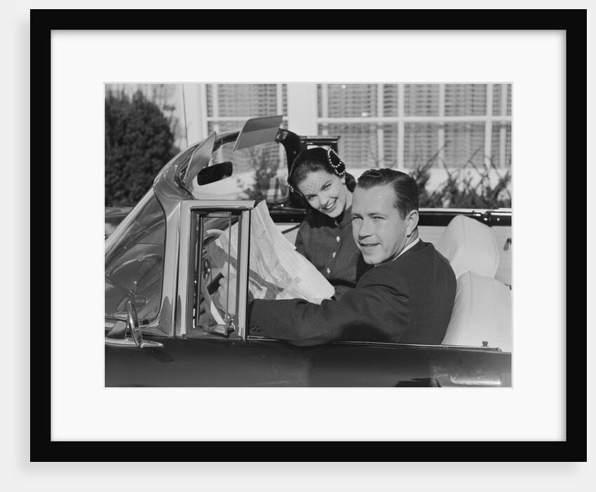 Husband wife man woman in automobile reading map by Anonymous