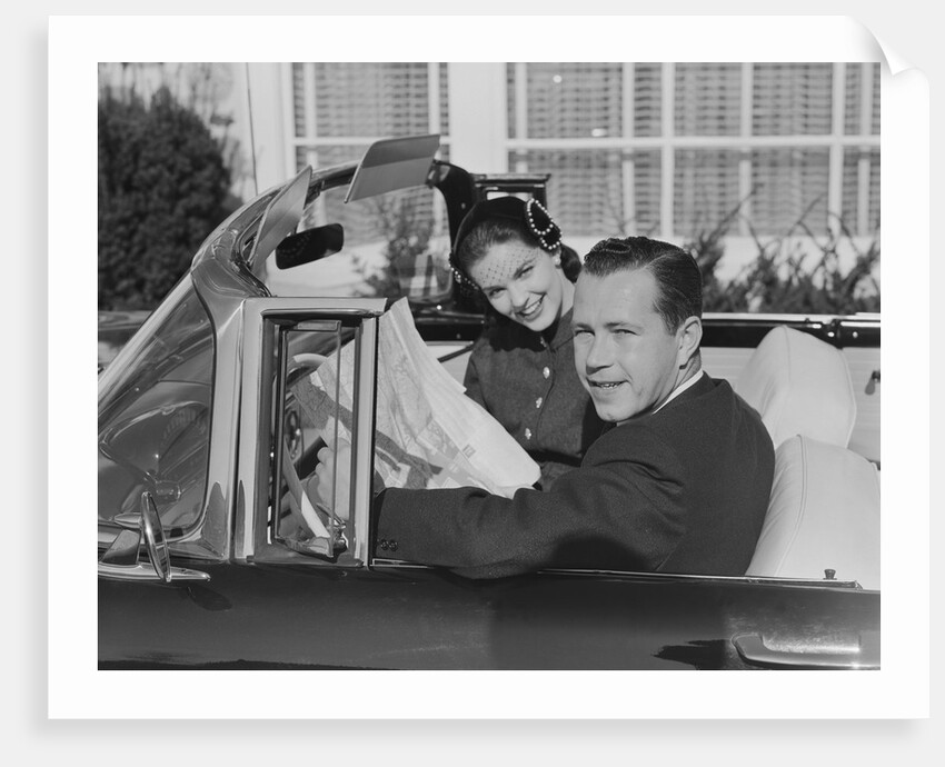 Husband wife man woman in automobile reading map by Anonymous