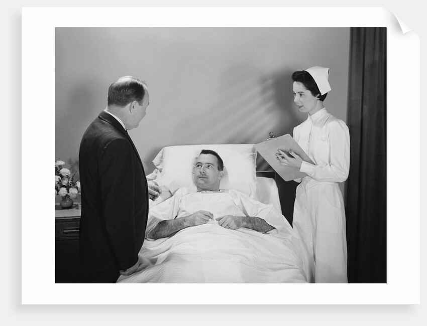 Man doctor woman nurse talking with male patient lying in hospital bed by Anonymous