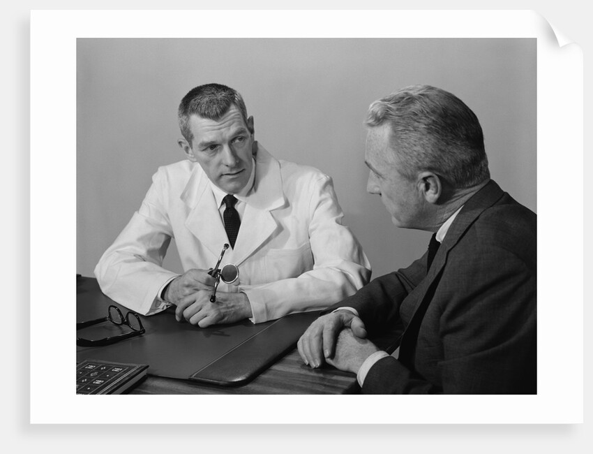 Doctor sitting at desk talking to male patient by Anonymous
