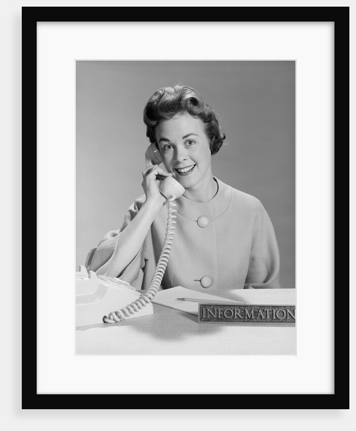 Smiling woman secretary talking on telephone information desk by Anonymous