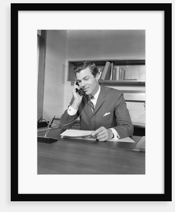 Businessman executive at desk talking on telephone by Anonymous