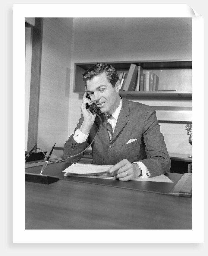Businessman executive at desk talking on telephone by Anonymous
