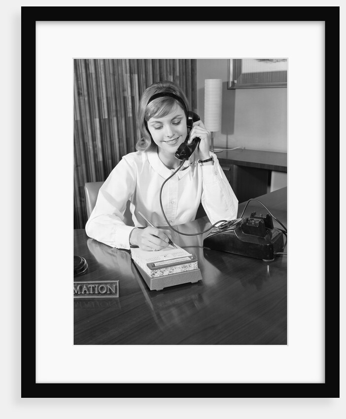 Secretary receptionist talking on telephone writing into desk calendar by Anonymous