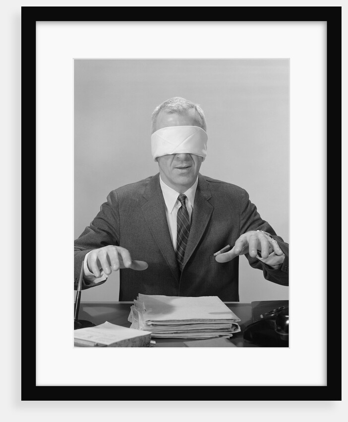 Business man hands hovering over desk wearing blindfold by Anonymous