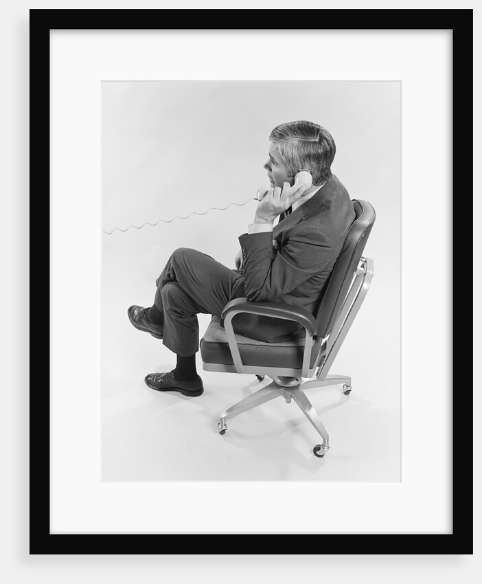 Profile executive businessman sitting in office chair talking on telephone by Anonymous