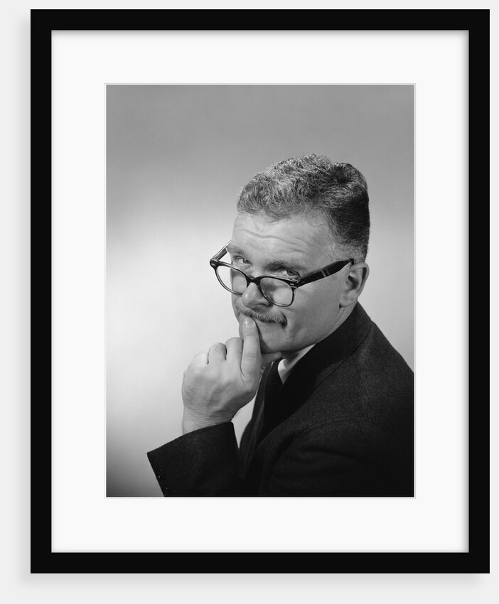 Middle aged man wearing eyeglasses low on nose quizzical facial expression by Anonymous
