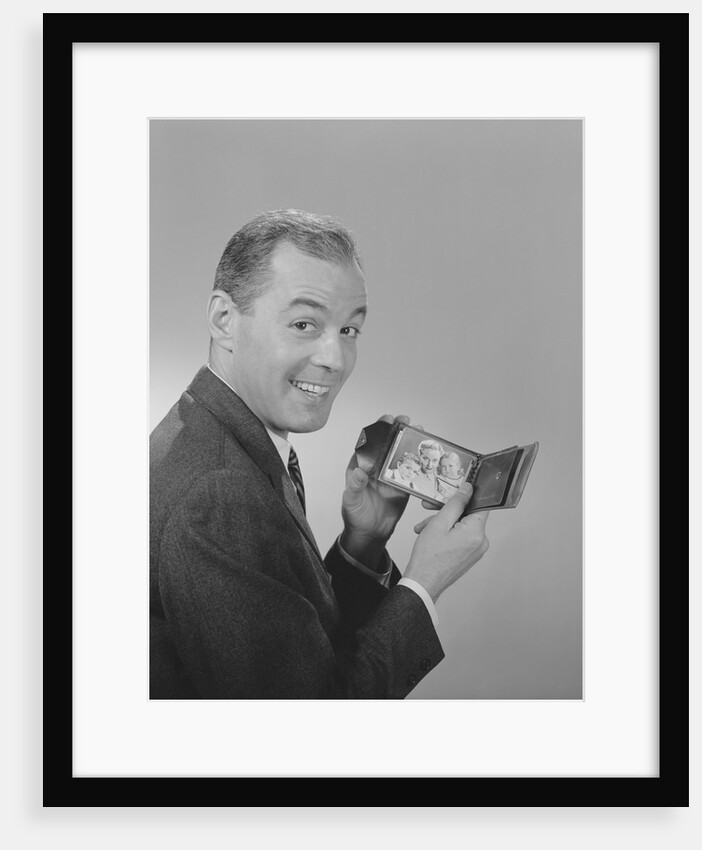 Man smiling holding wallet showing photo of family by Anonymous