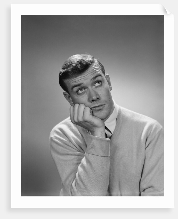 Young man hand to cheek looking up quizzical wondering thoughtful facial expression by Anonymous