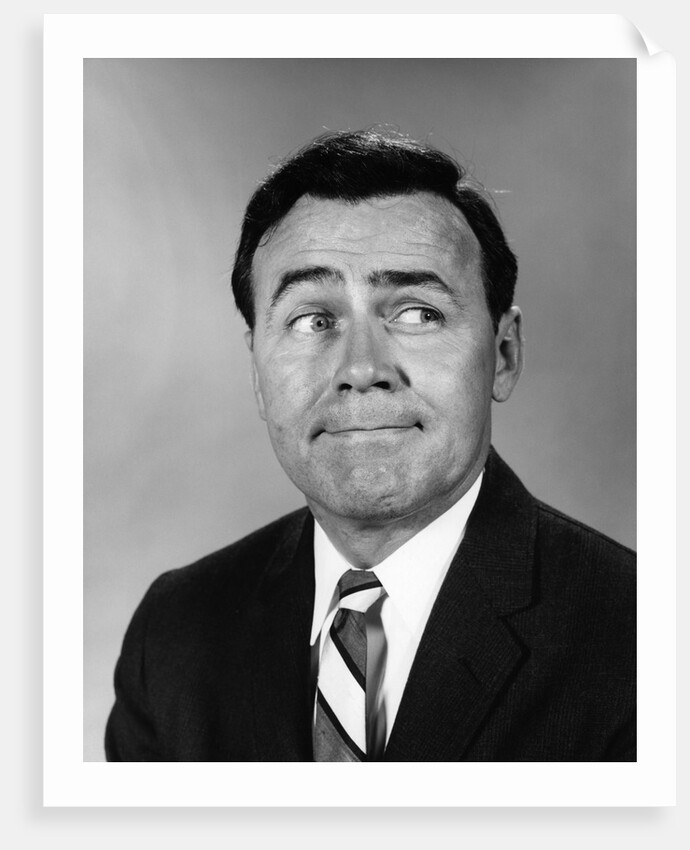 Businessman making funny face looking to the side by Anonymous