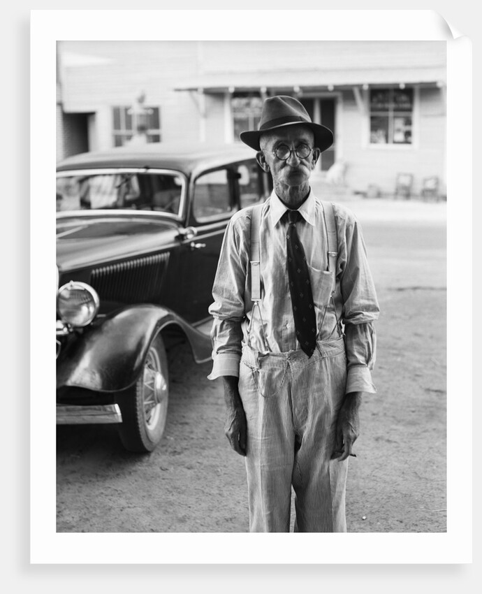 Portrait of old man wearing hat glasses tie & suspenders car in background by Anonymous