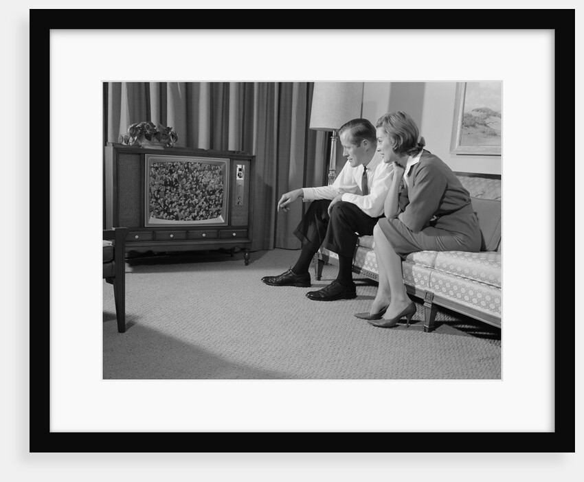 Couple man woman sitting on couch watching television by Anonymous