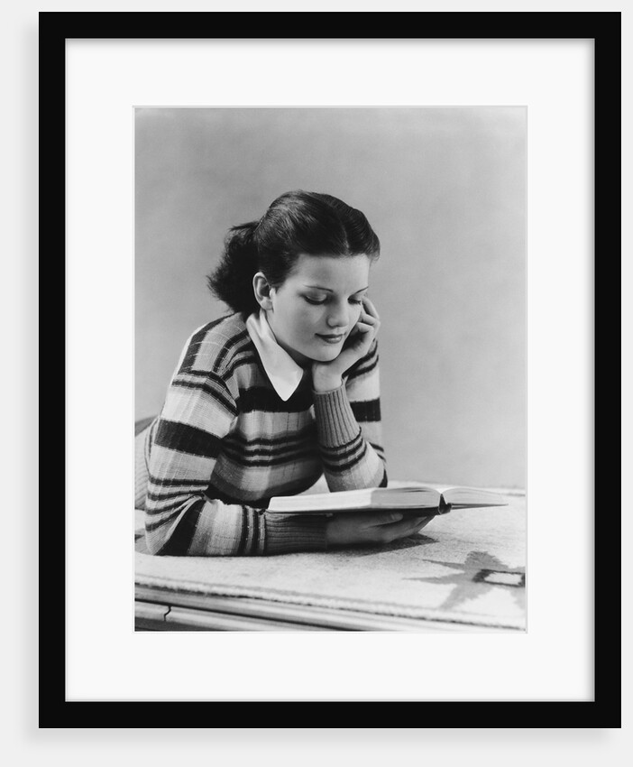 Young brunette woman teen striped sweater reading book studying by Anonymous