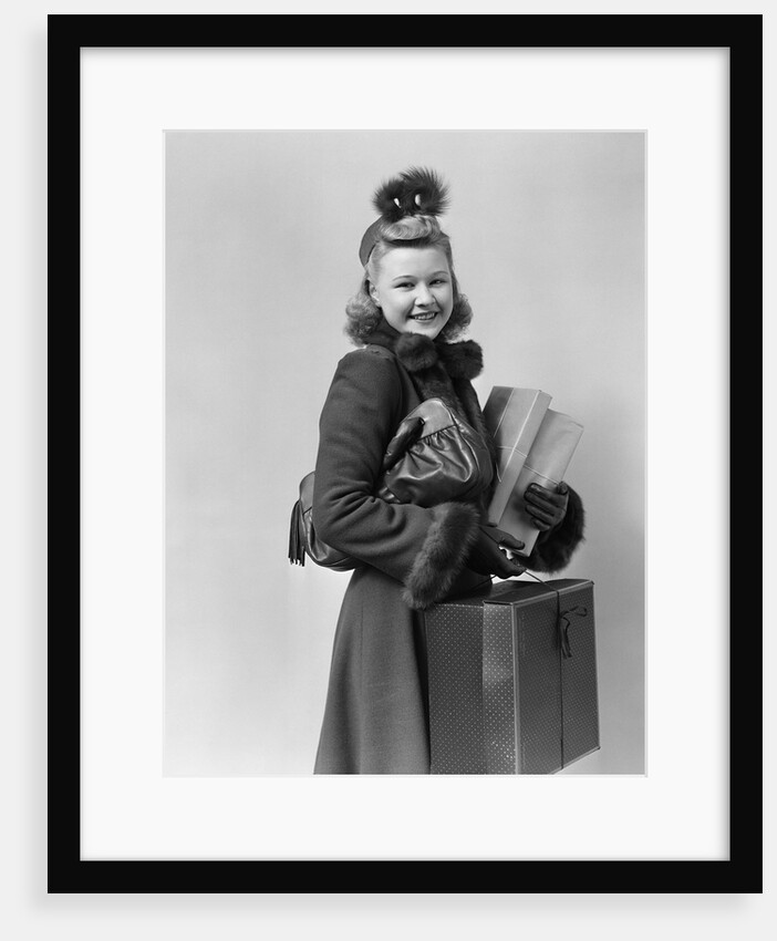 Smiling young blond woman wearing hat fur trimmed coat carrying packages by Anonymous