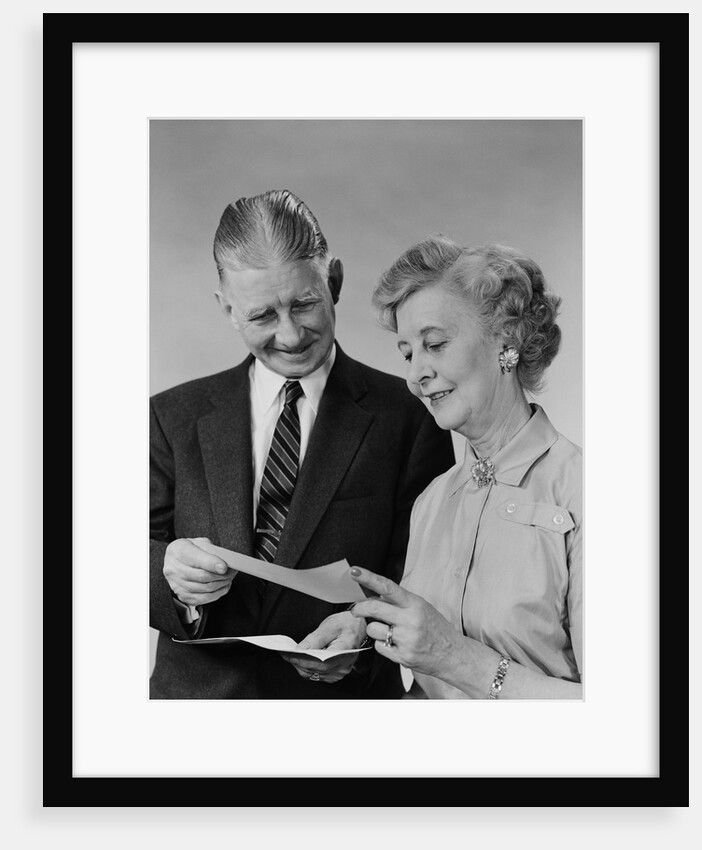 Senior couple man woman reading holding check by Anonymous