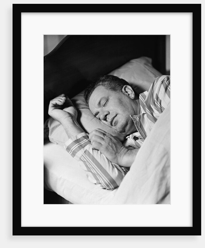 Man asleep sleeping in bed wearing pajamas by Anonymous