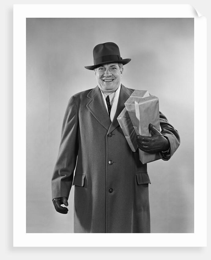 Smiling man carrying shopping boxes wearing hat coat gloves by Anonymous
