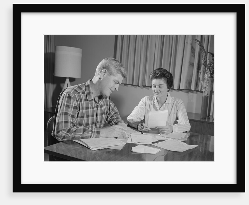 Couple man woman at table working on household accounts bills by Anonymous
