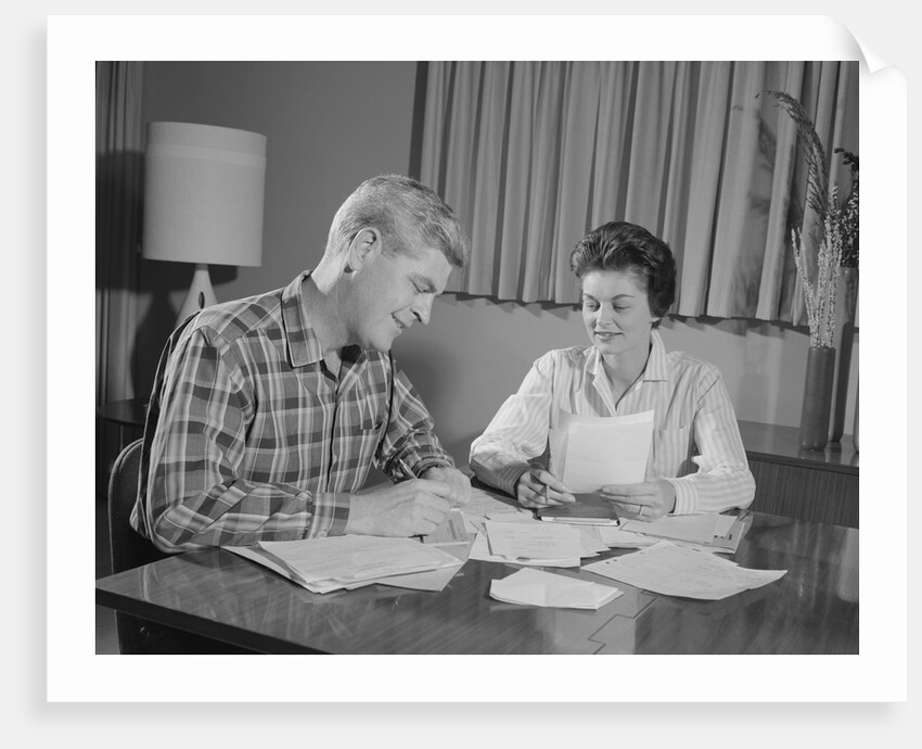 Couple man woman at table working on household accounts bills by Anonymous