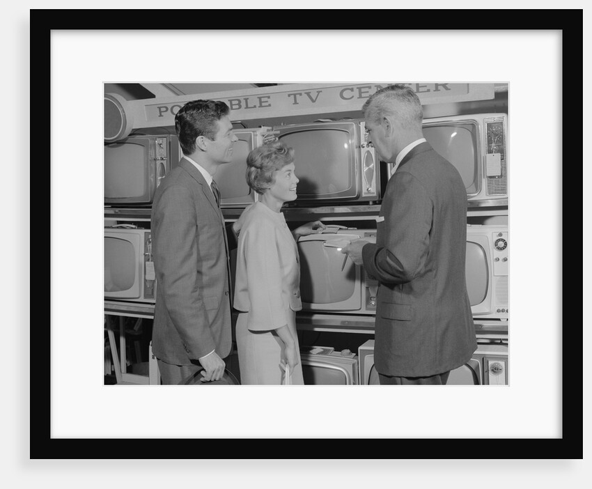 Couple shopping for portable tv being helped by salesman by Anonymous