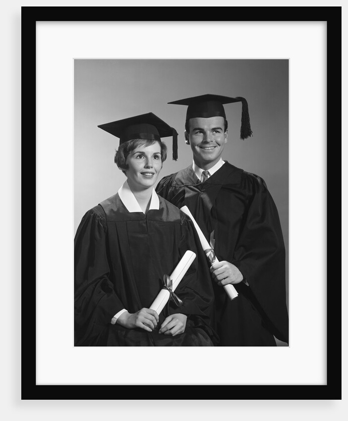 Portrait couple man woman in graduation robes holding diplomas smiling by Anonymous