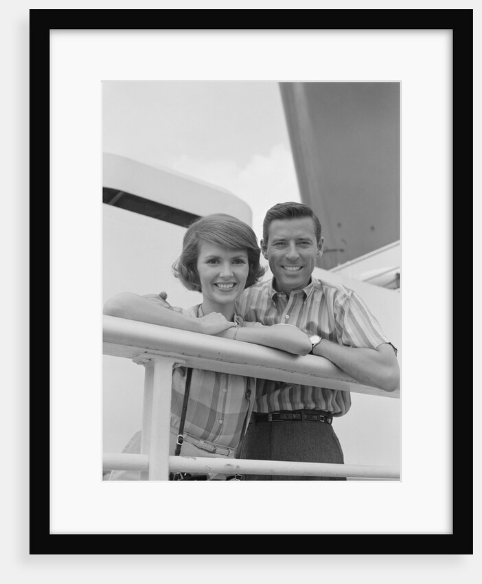 Portrait smiling couple standing by shipboard rail by Anonymous