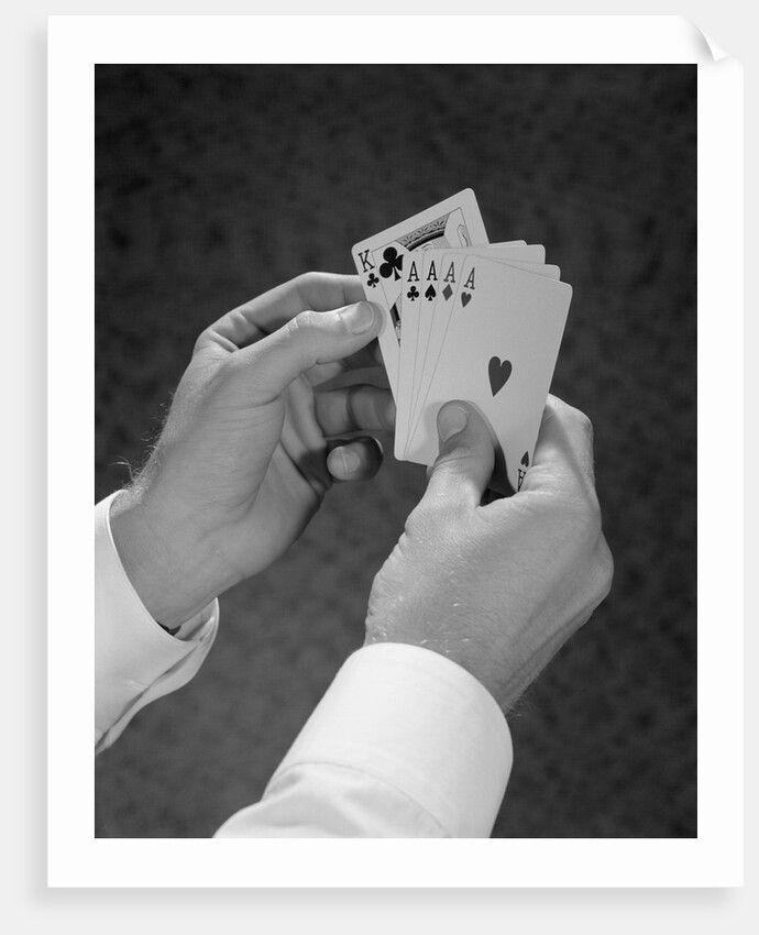 Male hands holding hand poker cards 4 aces and a king by Anonymous