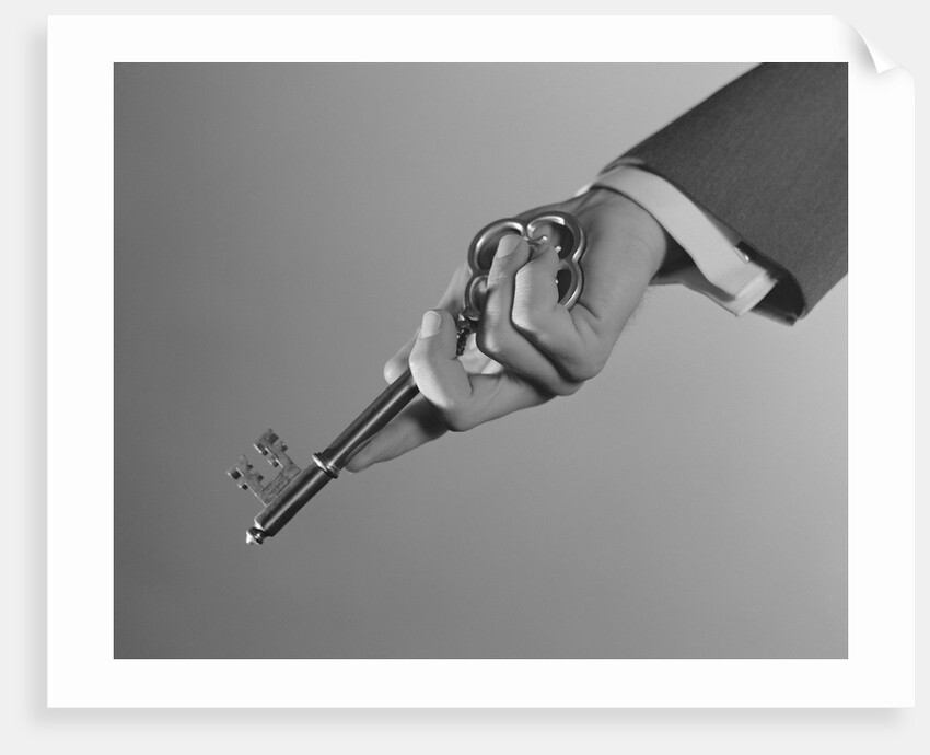 Male hand holding large key by Anonymous