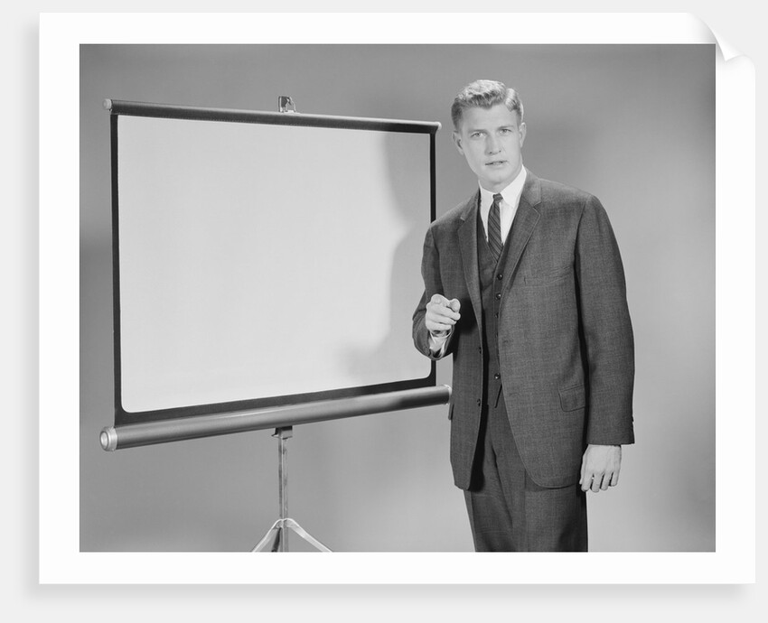 Man standing beside blank screen ready for presentation by Anonymous