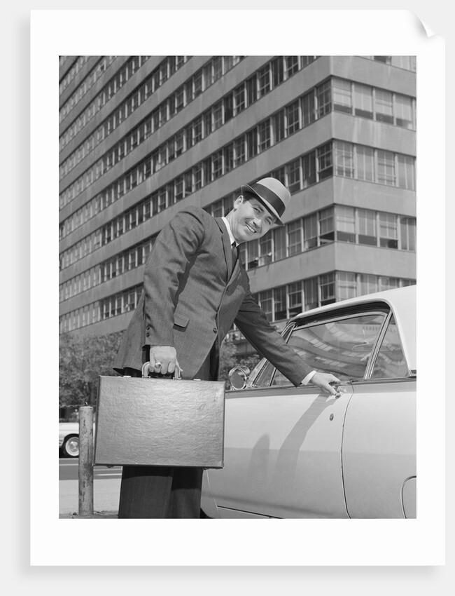 Businessman carrying briefcase getting into car on urban street by Anonymous