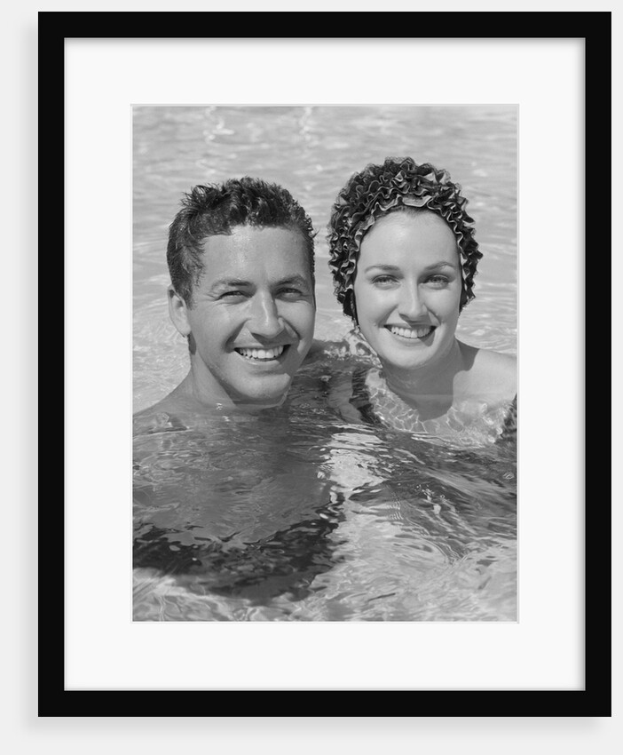 Smiling couple man woman in swimming pool by Anonymous