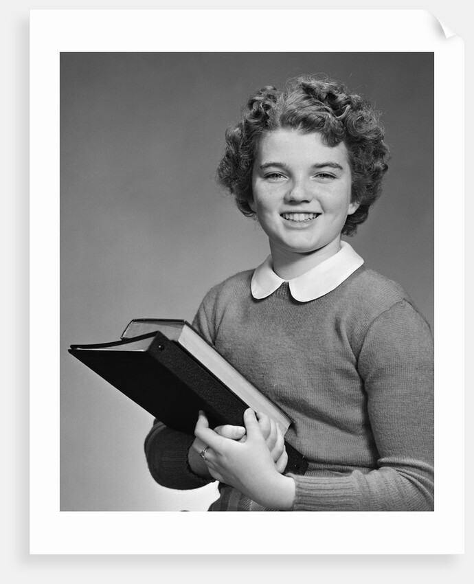 Adolescent teen girl smiling portrait holding school books by Corbis