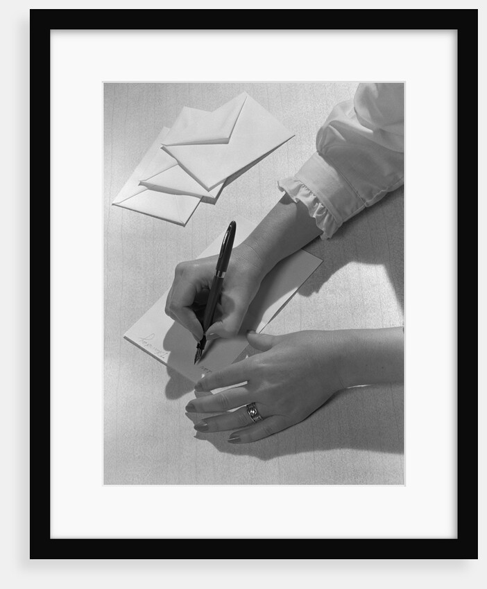 Woman's hands holding pen writing letter on stationery by Anonymous