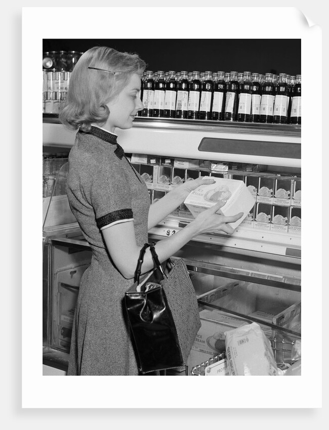Blond woman selecting ice cream frozen food section supermarket by Anonymous
