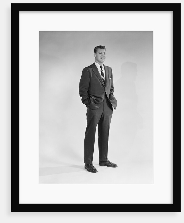 Portrait smiling man standing with hands in pockets wearing suit and tie by Anonymous