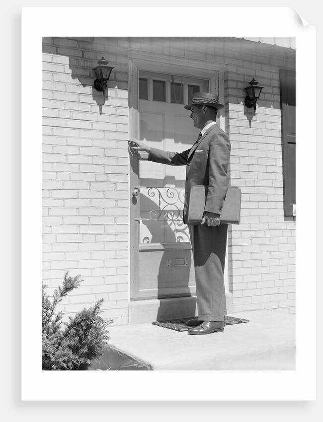 Salesman wearing suit tie hat carrying briefcase ringing suburban house doorbell by Anonymous