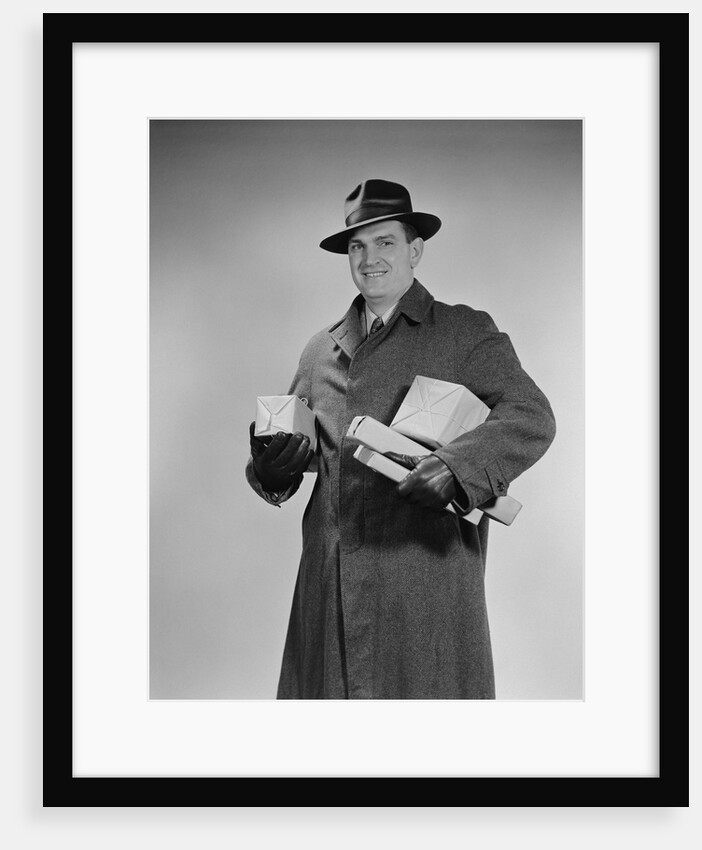 Man wearing winter coat hat gloves holding packages parcels by Anonymous