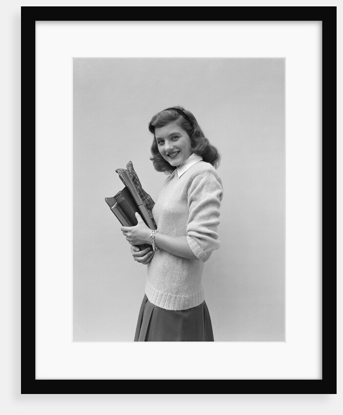Smiling brunette teen student wearing sweater carrying school books by Anonymous
