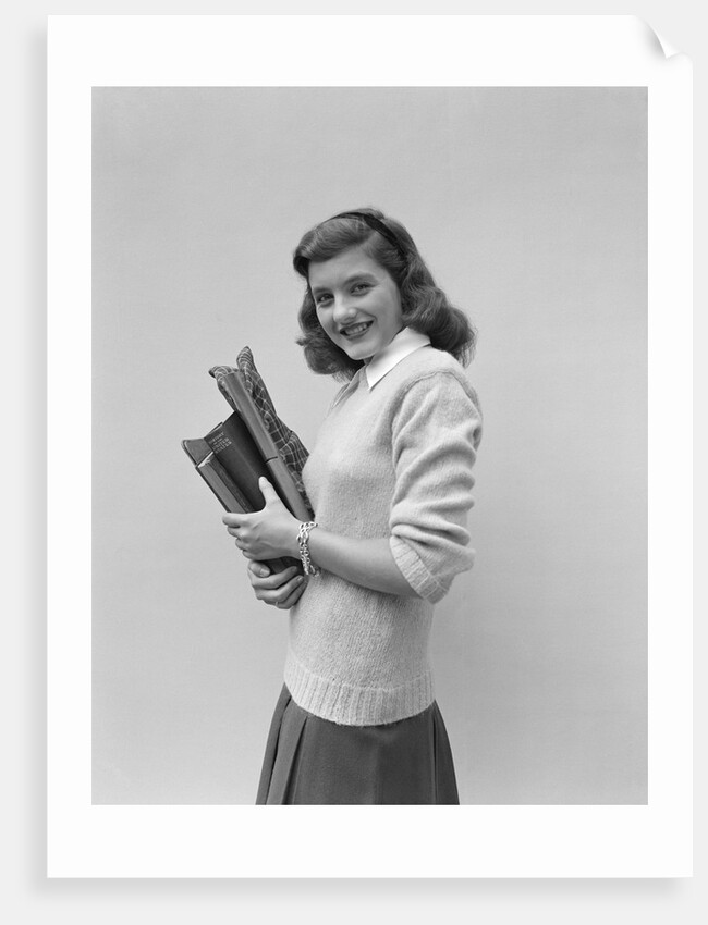 Smiling brunette teen student wearing sweater carrying school books by Anonymous