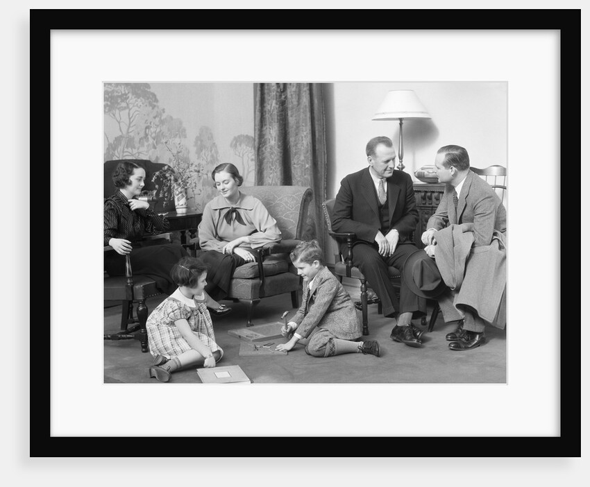 Family mother father two kids playing on floor visiting with another couple by Anonymous